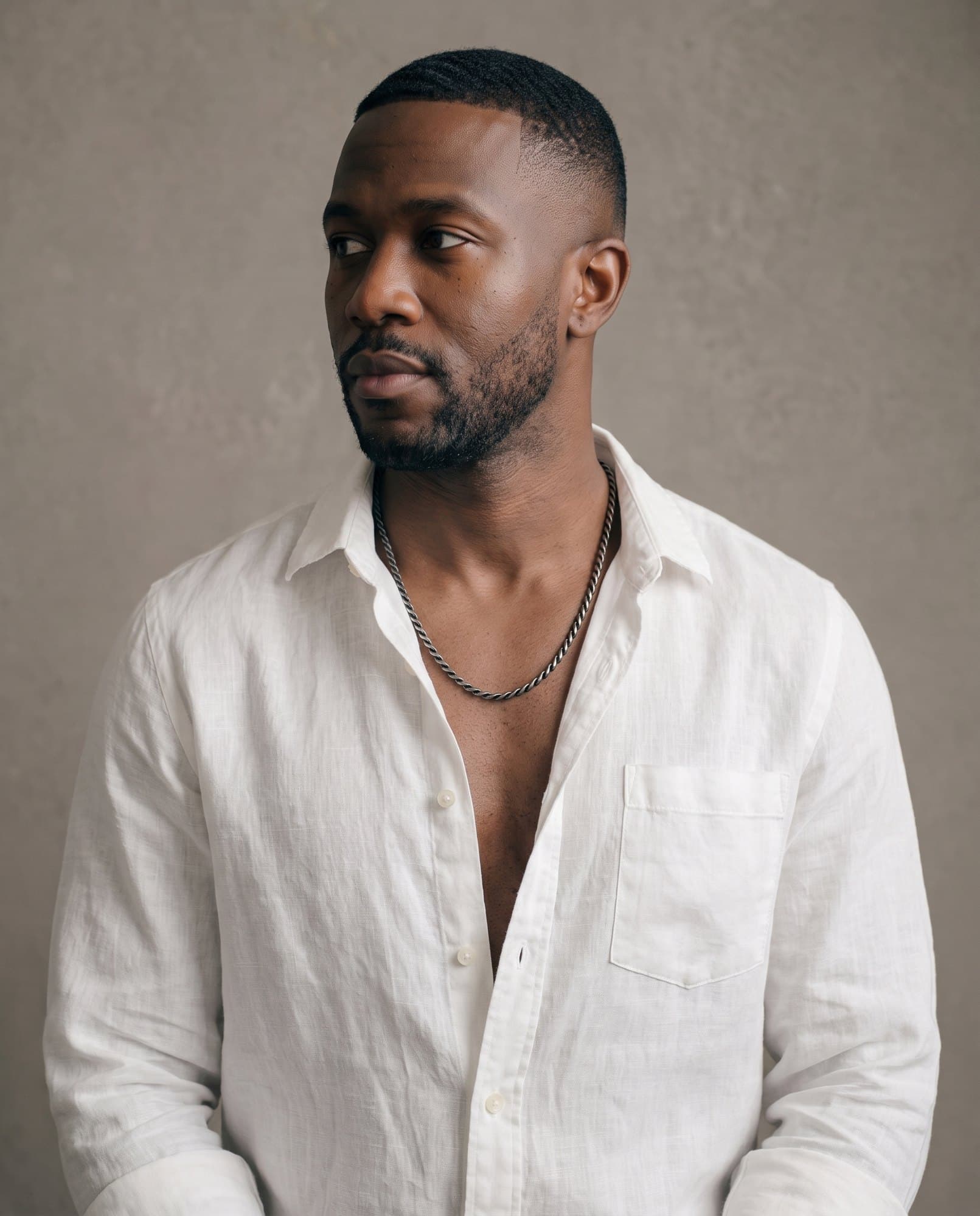 A man in an open white shirt, the Memphis Rope Chain resting on his collarbones.