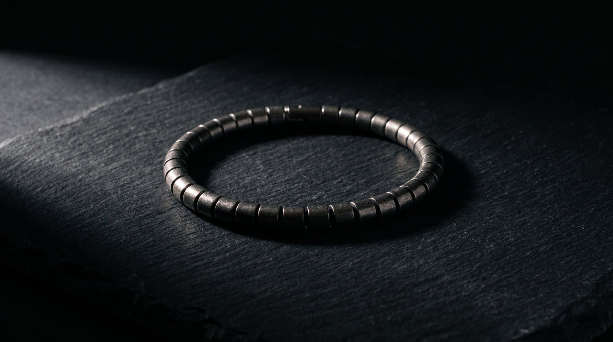 The Meridian Barrel Chain on black slate under a single raking light.