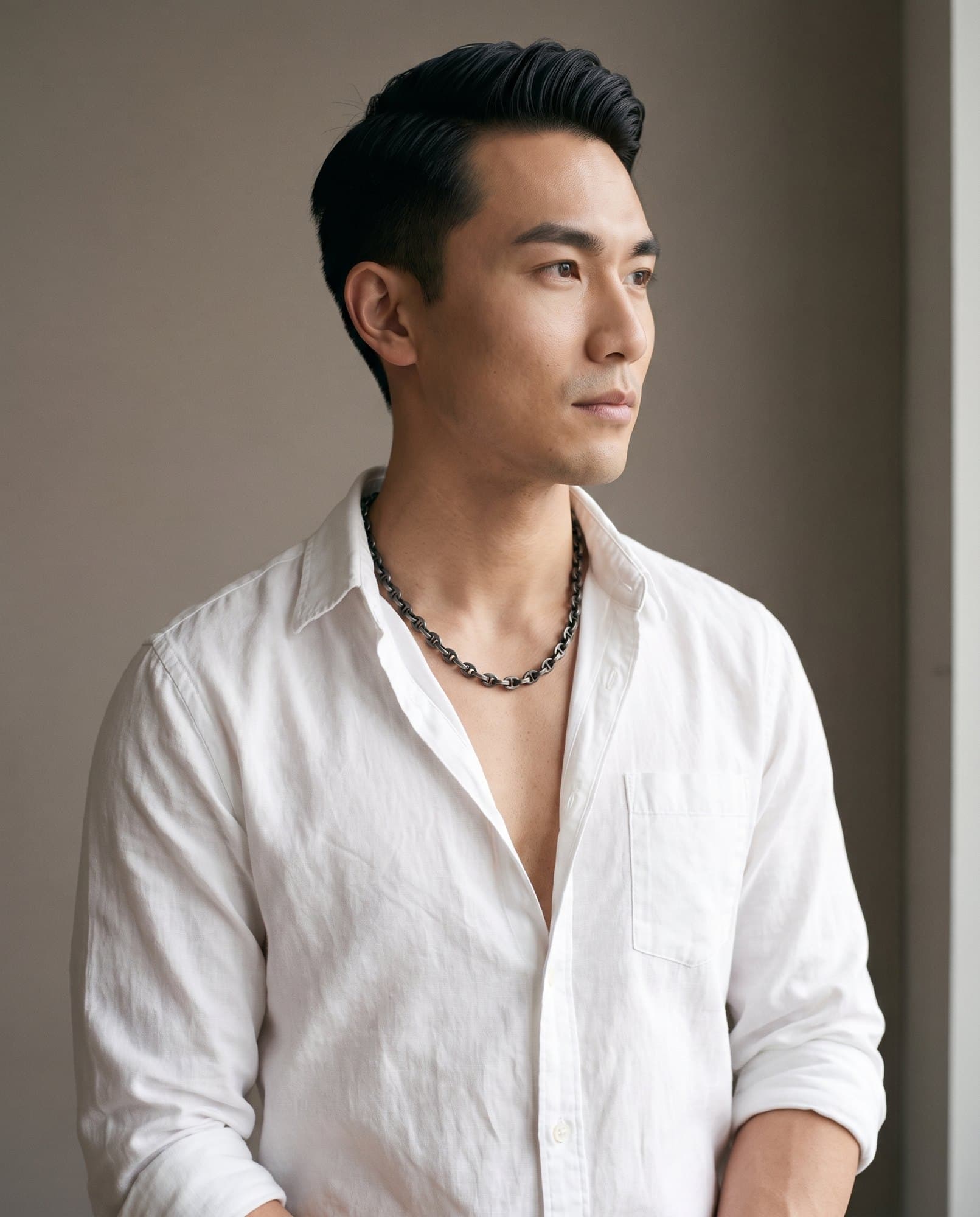 A man in an open white shirt, the Nile Bean Chain resting on his collarbones.