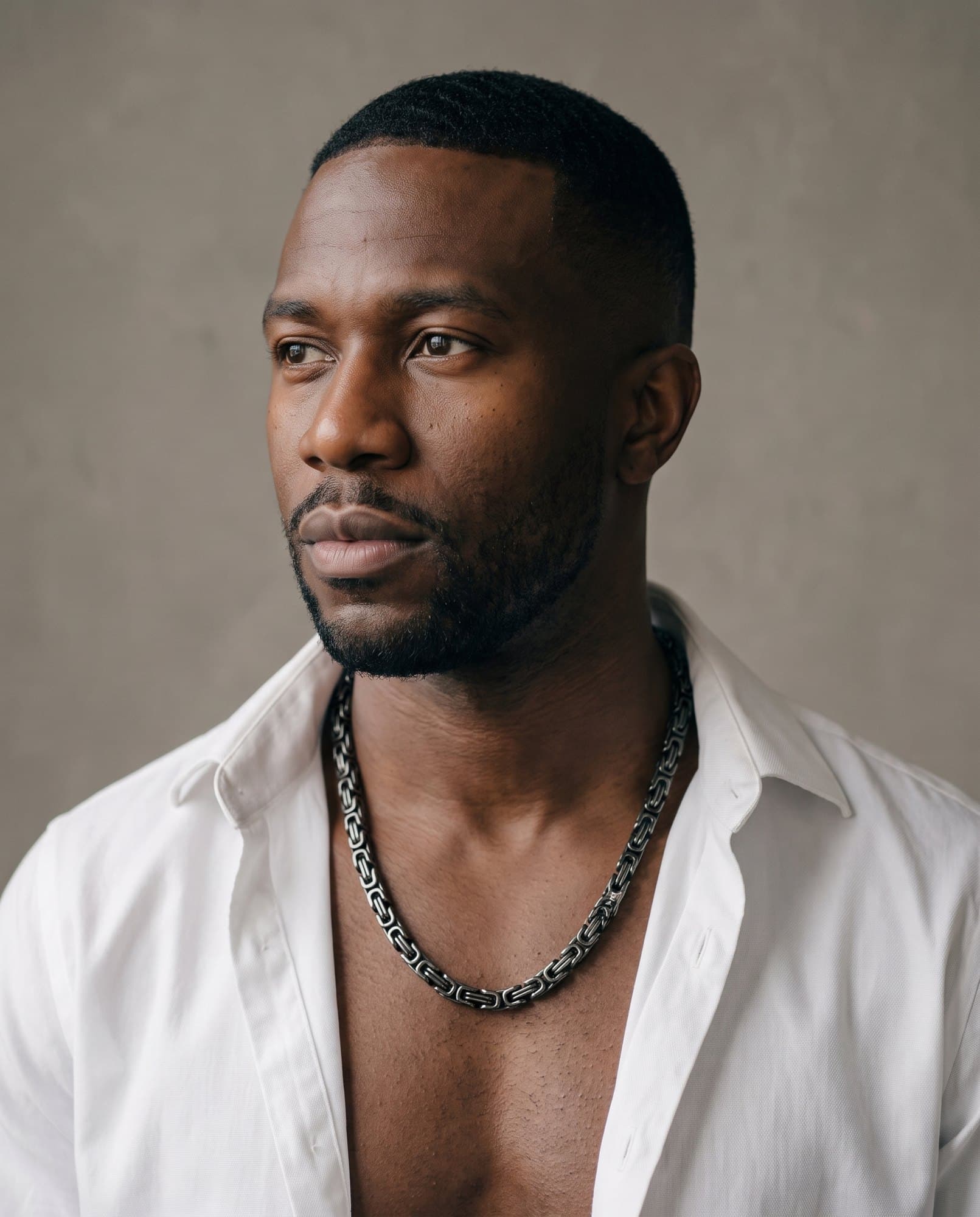 A man in an open white shirt, the Pharaoh King Chain resting on his collarbones.