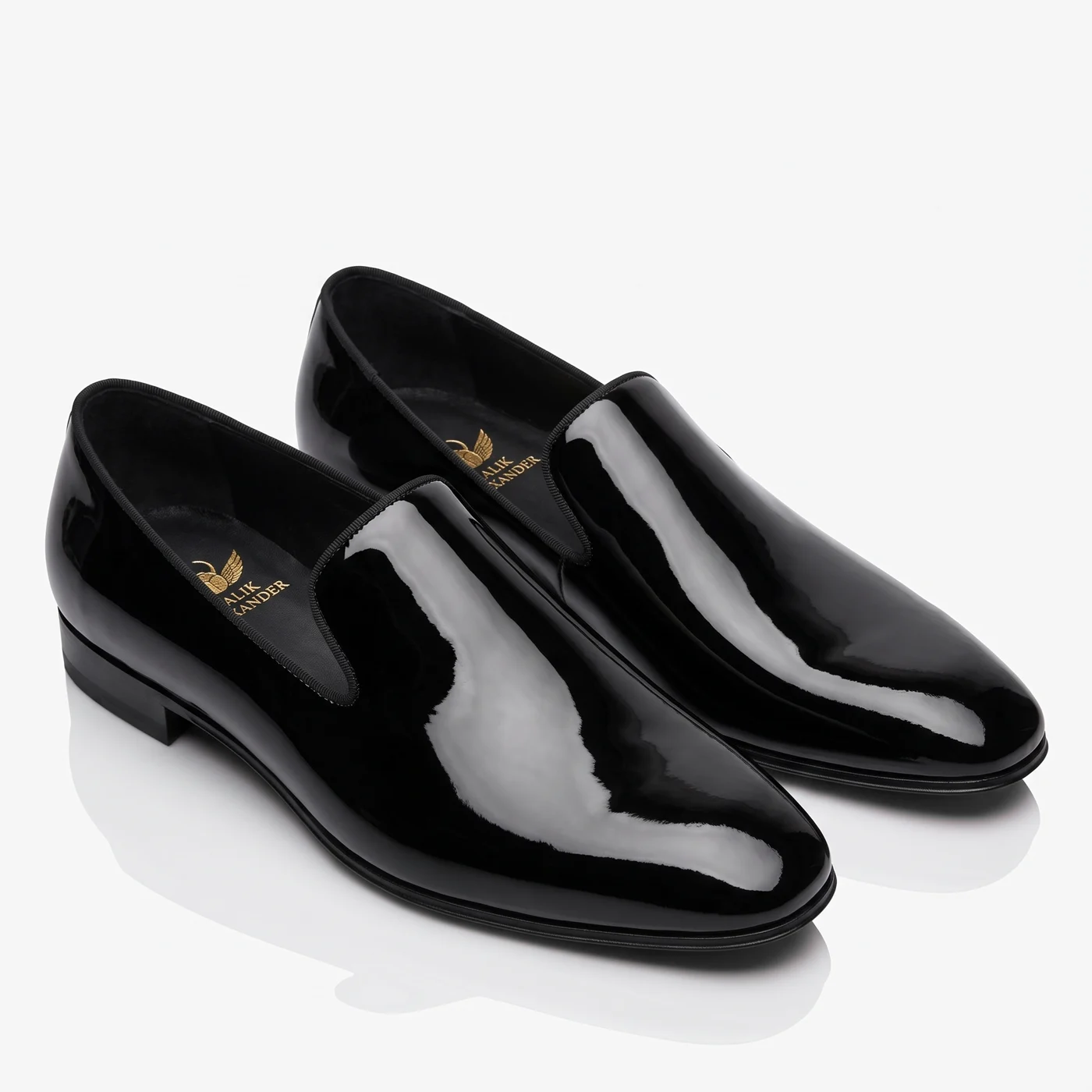 A pair of black patent slippers