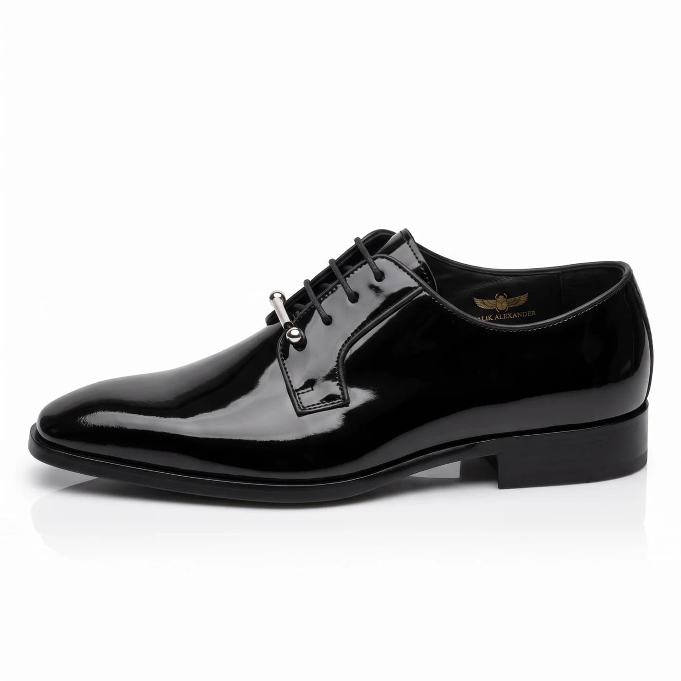 Black patent leather derby in side profile, a silver bar across the lowest eyelets, black sole