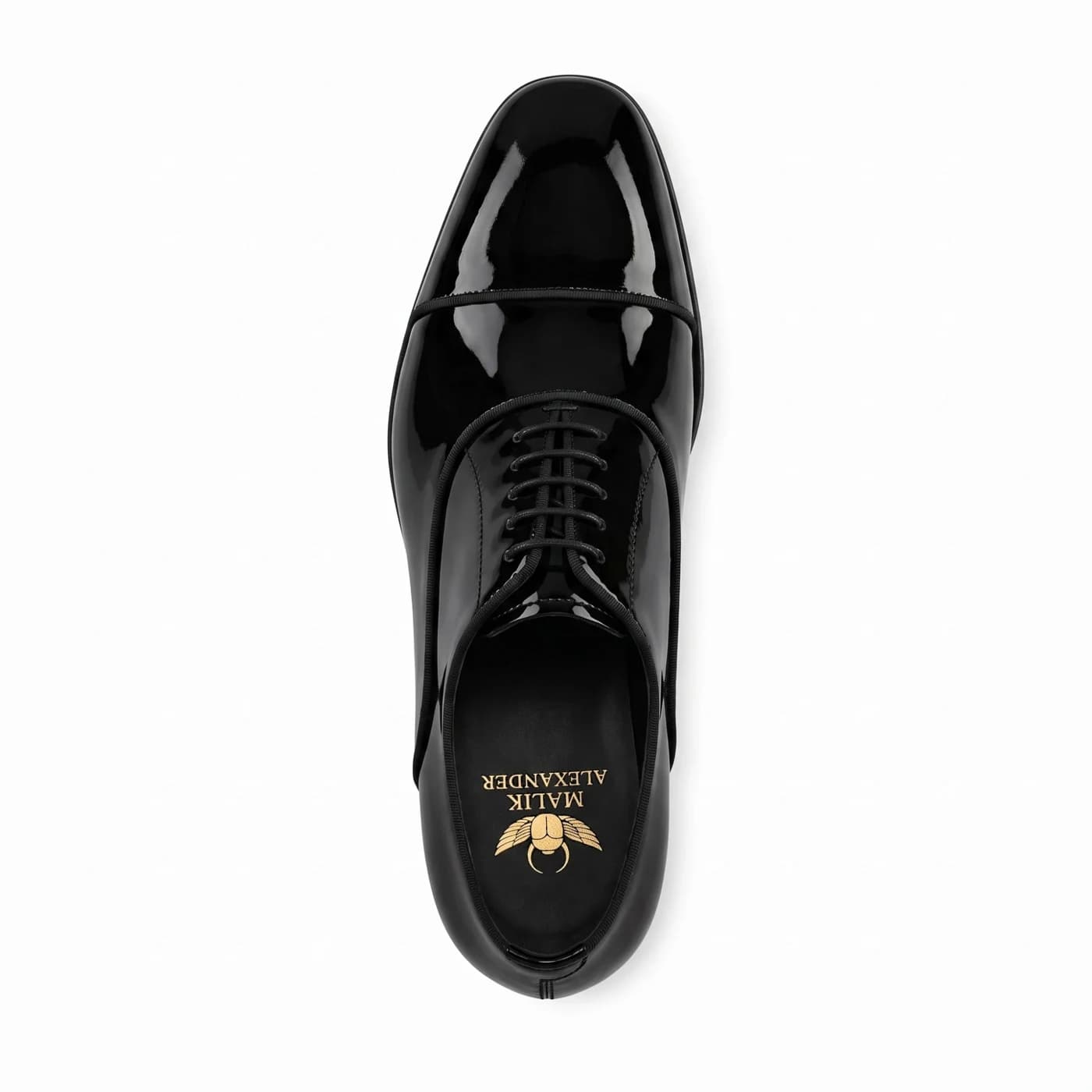 Black patent leather cap toe oxford from above, the Malik Alexander logo in gold on the black insole